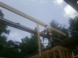 Carpenter setting a ridge beam over a new addition frame — Ice Dam Removal by Roofing Brothers in Lake Geneva