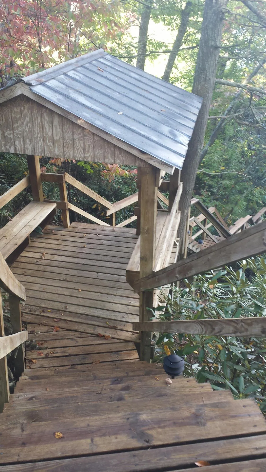 Metal roofed shelter over wooden steps on a wooded walkway — Skylight Repair & Installation work by our crew in Lake Geneva
